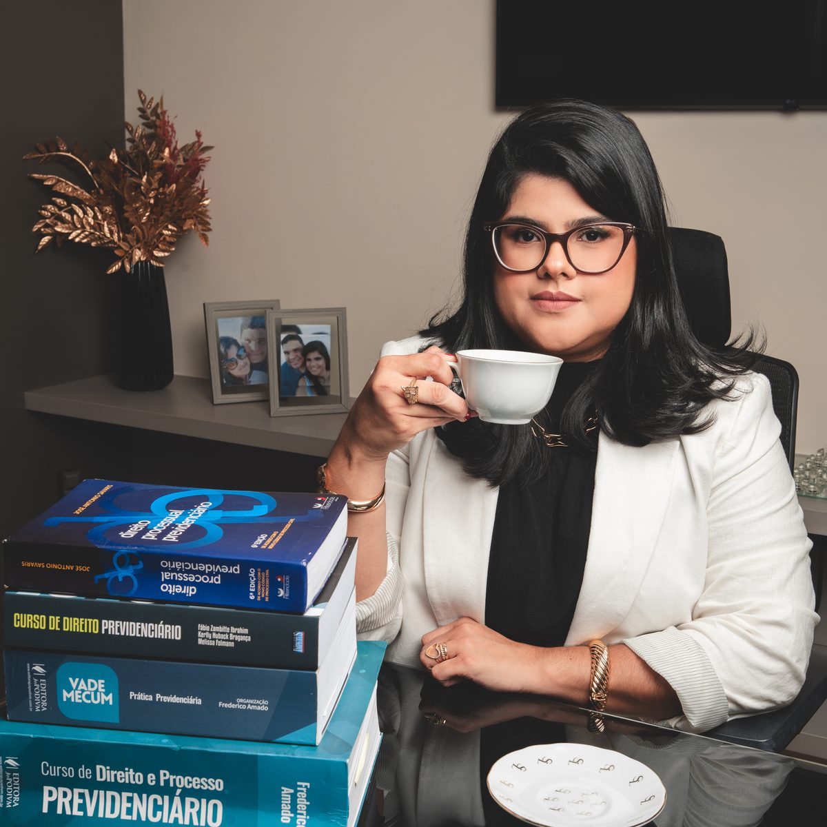 Dra. Danielly Melo em seu escritório, com os livros de Direito Previdenciário